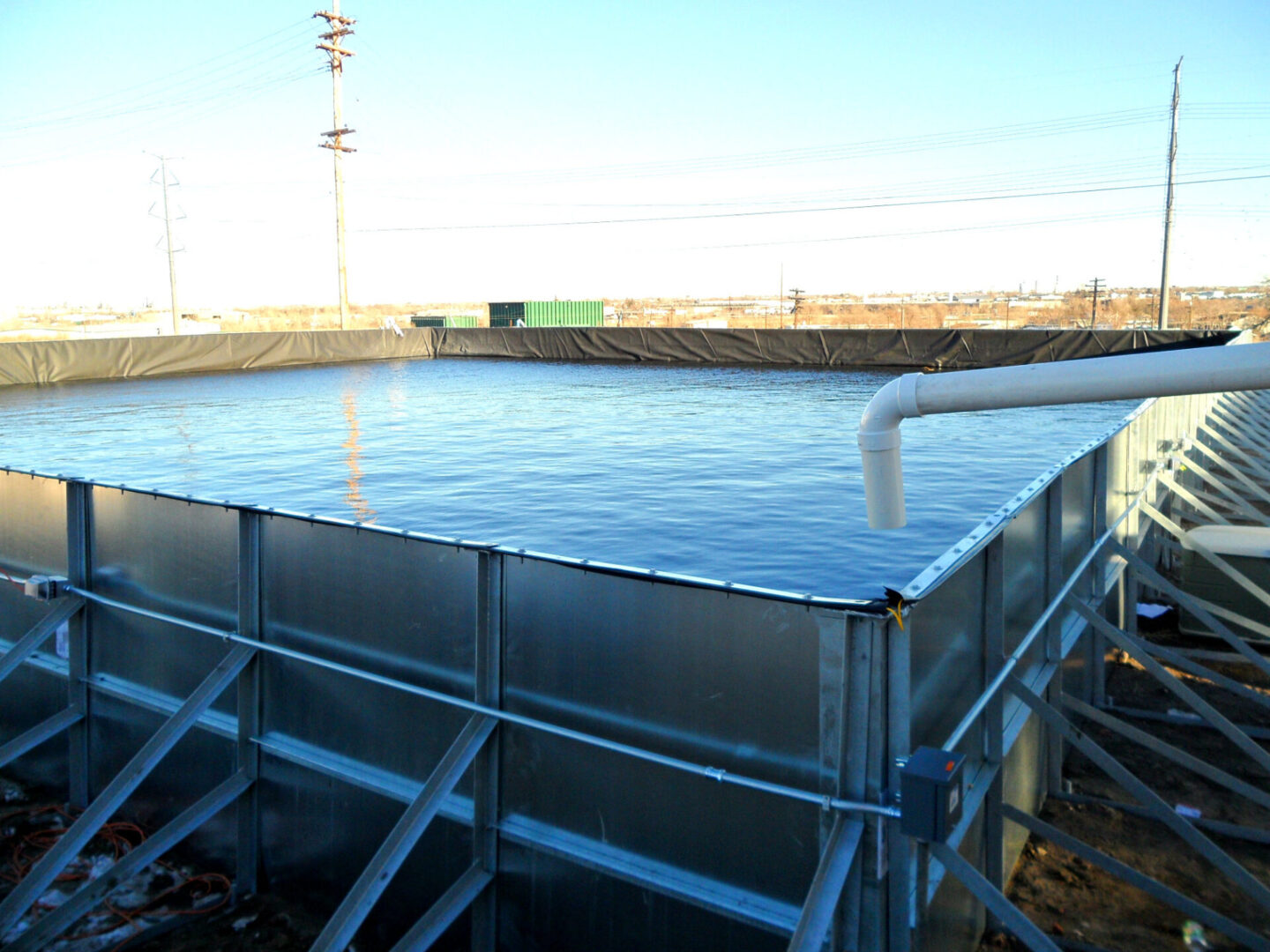 A large metal tank with water coming out of it.