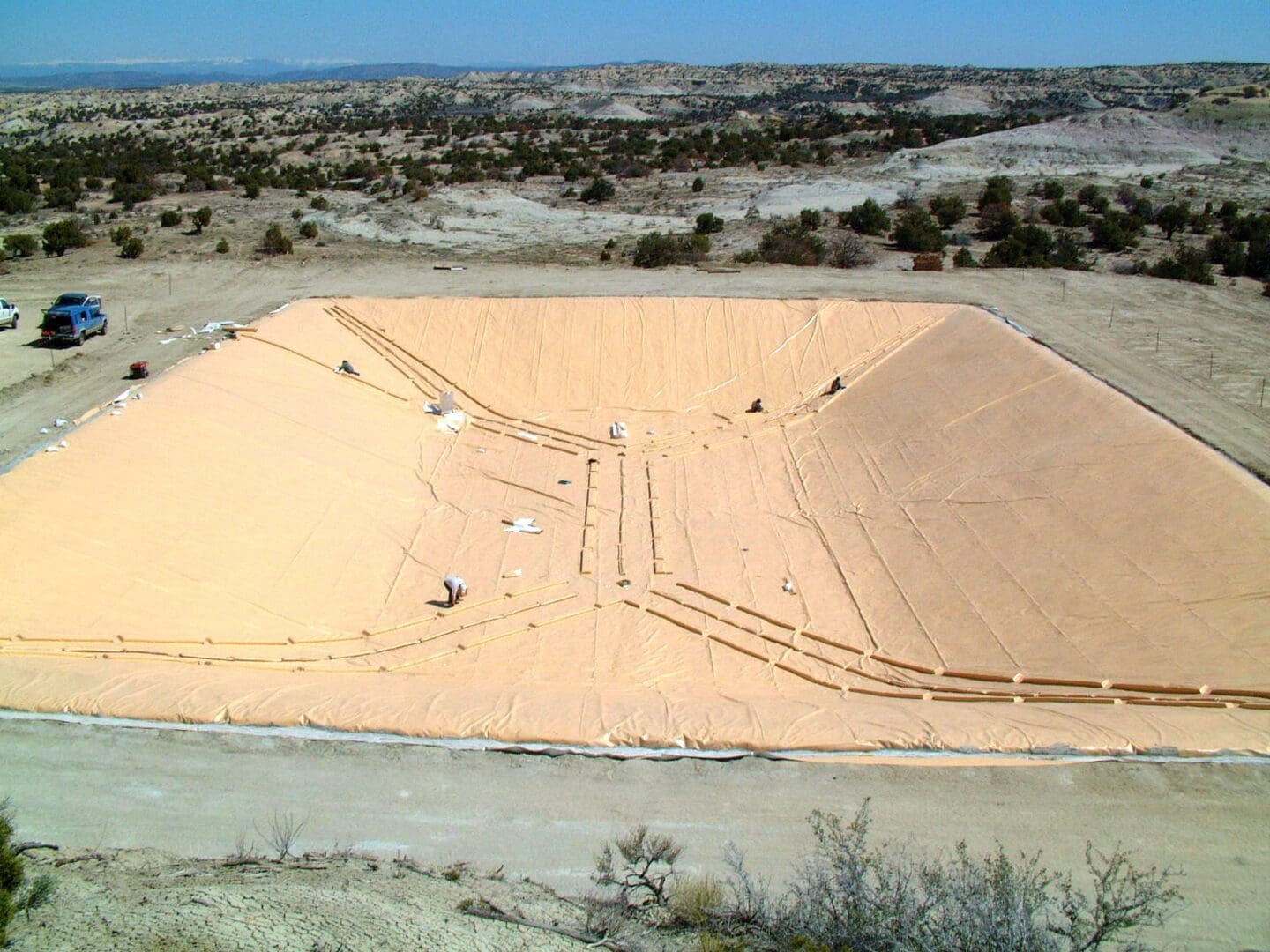 A large sand pit with people working on it.