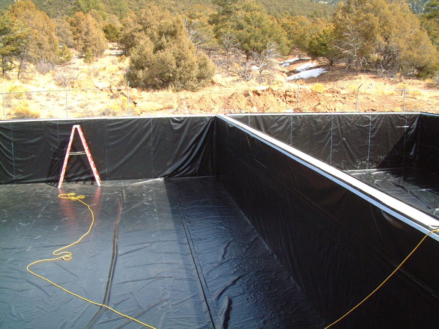 A black tarp covering the bottom of a pool.