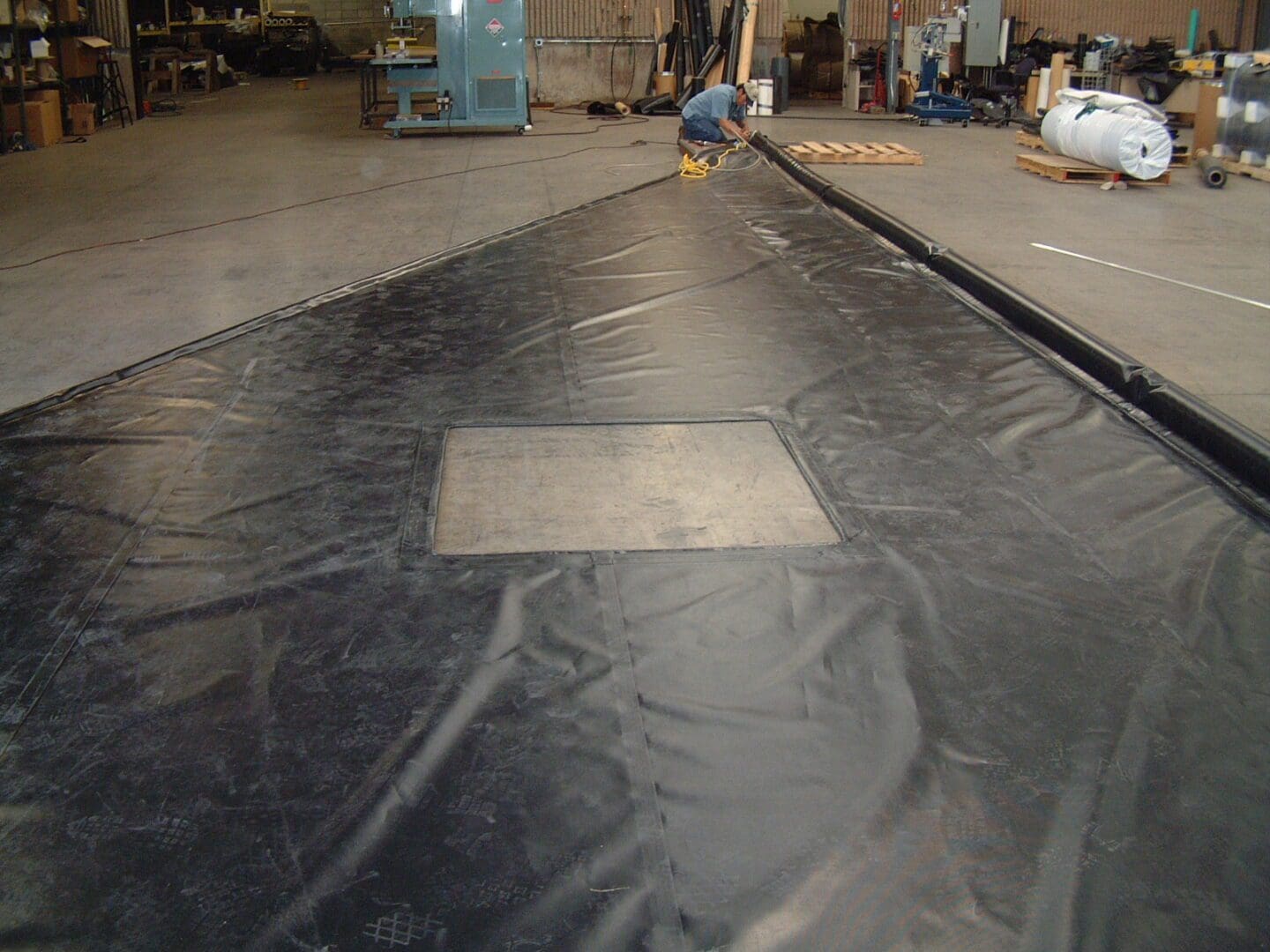 A man working on the floor of an industrial building.