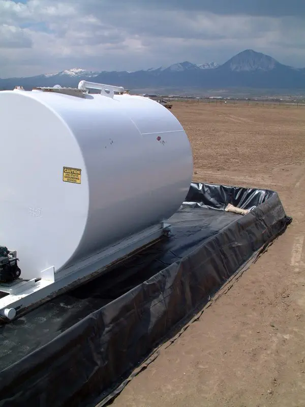 A tank sitting on top of a dirt field.