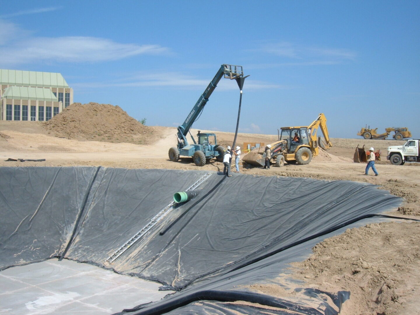 A crane is lifting a large piece of plastic.