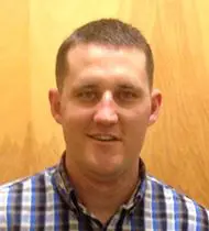 A man in plaid shirt smiling for the camera.