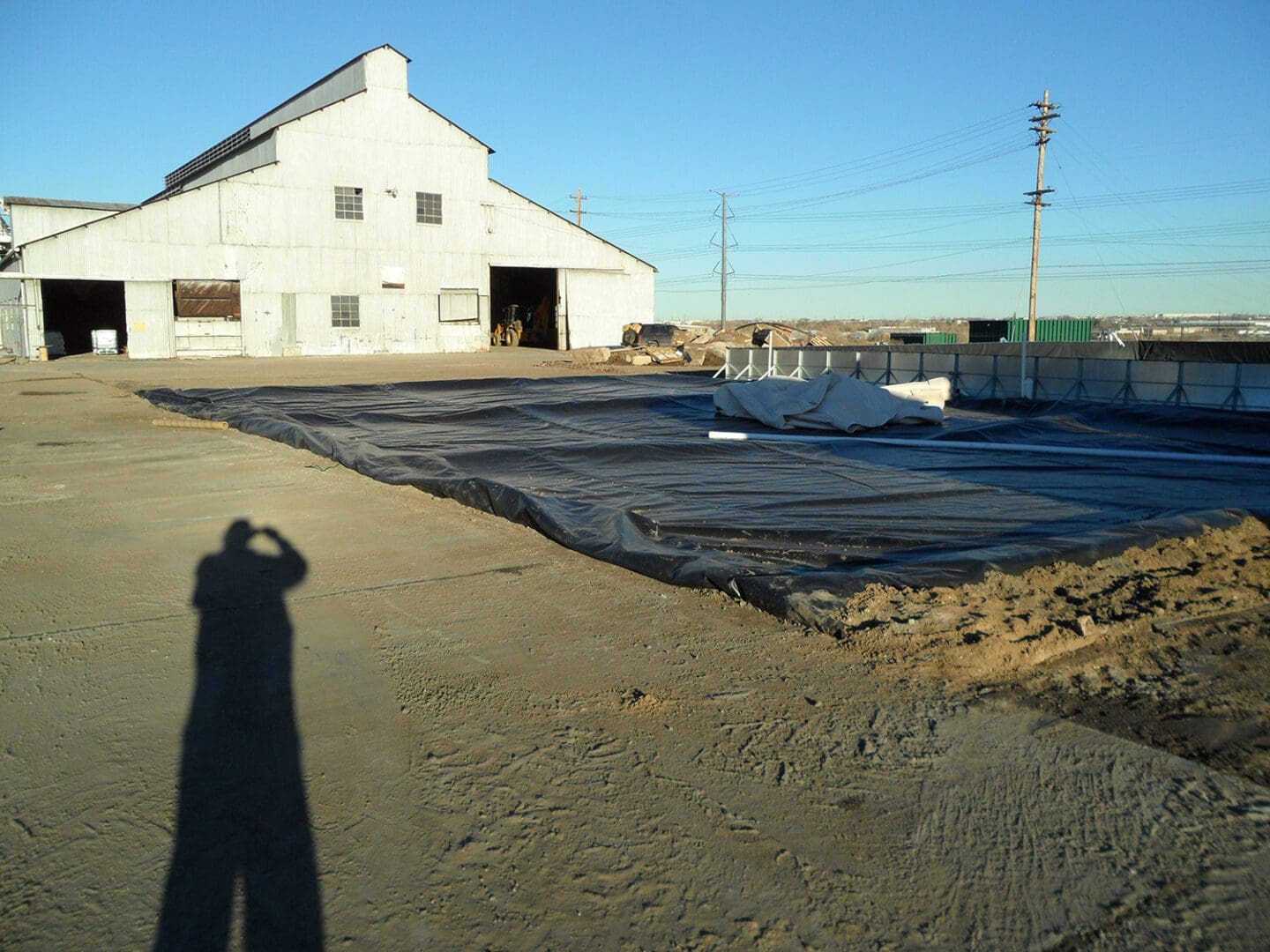 A person is standing in front of an old barn.