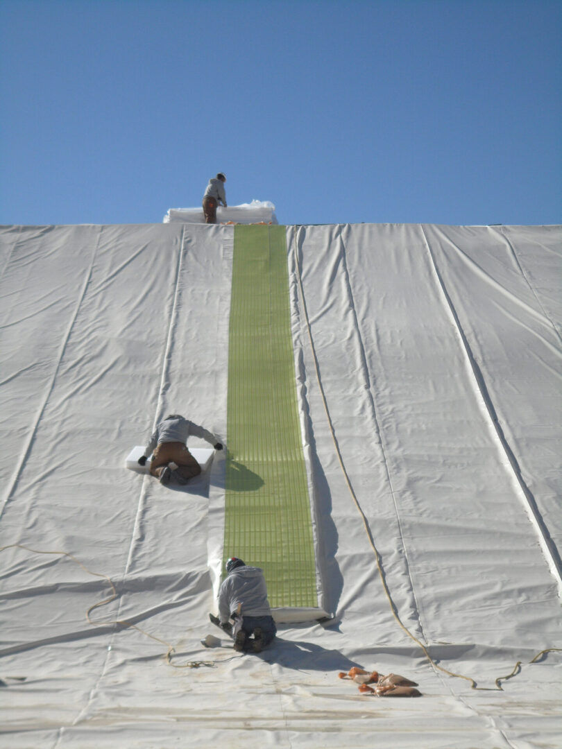 A man is laying on the ground next to a green mat.