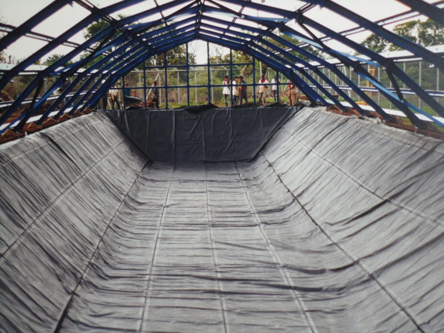 A large area of water with a roof and tarps.
