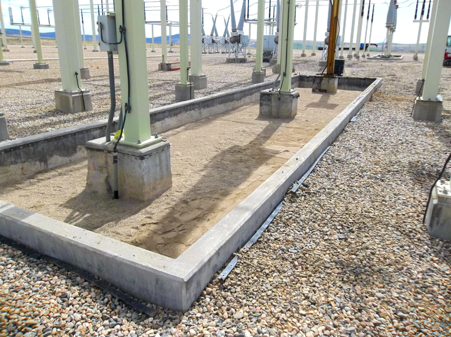A concrete slab with cement pillars and gravel.