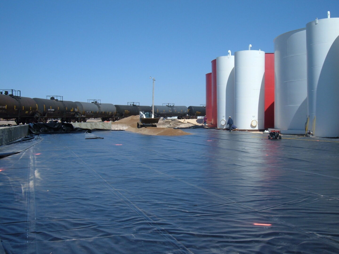A view of some water and several large tanks.
