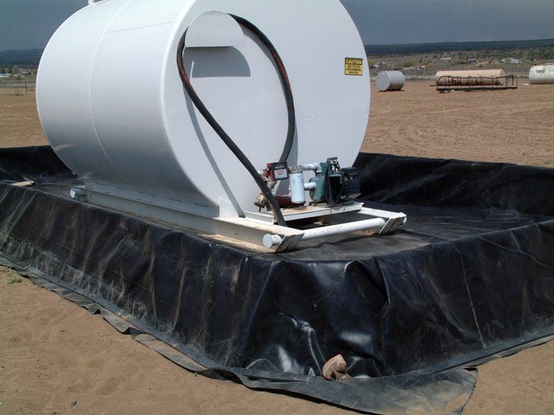 A large white tank sitting on top of a black tarp.