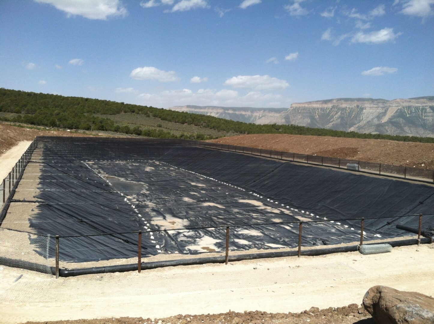 A large black solar panel sitting on top of a field.