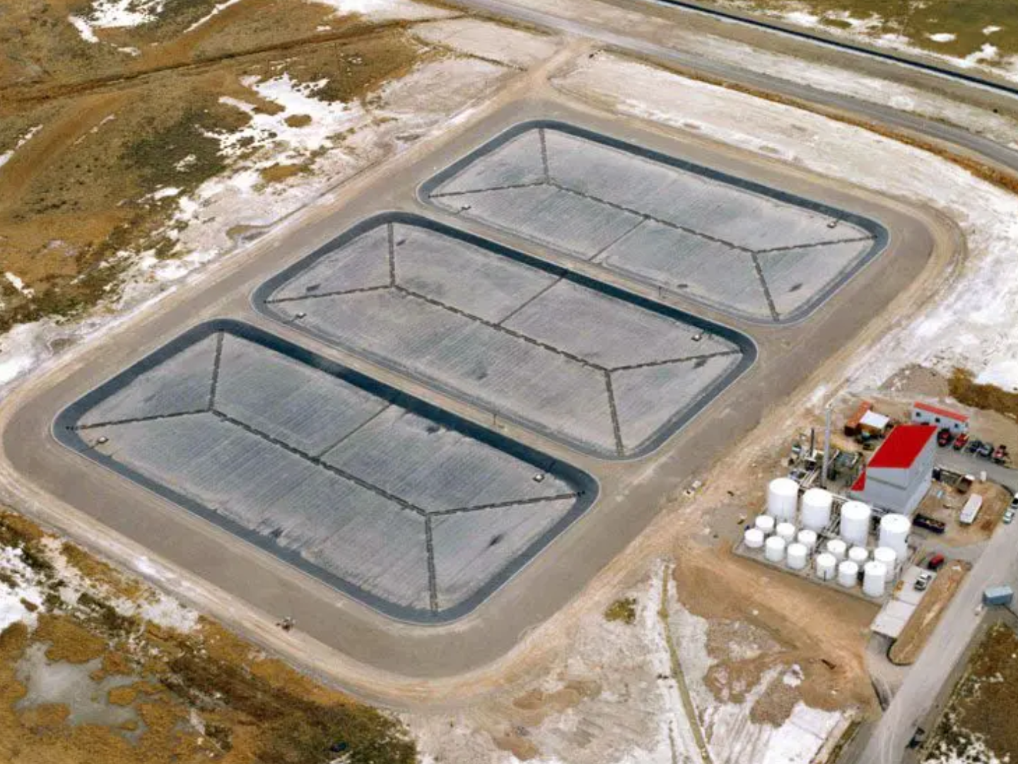 A large concrete area with three large tanks.